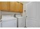 Laundry room with washer, dryer, and wood cabinets at 1122 Hacienda Cir, Kissimmee, FL 34741