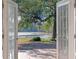 Backyard view from the home featuring a lake and lush trees as seen through open french doors at 1254 Seminola Blvd, Casselberry, FL 32707