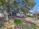 Expansive backyard featuring mature trees, lush greenery, a wooden deck, and a charming swing at 1254 Seminola Blvd, Casselberry, FL 32707