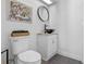 Modern powder room with vessel sink, white cabinets, and unique artwork at 1254 Seminola Blvd, Casselberry, FL 32707