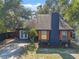Eye-level exterior of a charming home with blue siding, wooden accents, and mature trees at 1254 Seminola Blvd, Casselberry, FL 32707