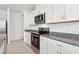 White kitchen cabinets with granite counters and stainless steel appliances, including a microwave and range at 1373 Current Pl, Haines City, FL 33844