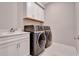 Convenient laundry room with washer, dryer, and white cabinets at 15913 Winding Bluff Dr, Montverde, FL 34756