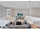 Elegant living room with white sofas, a black accent chair, and a large TV at 15913 Winding Bluff Dr, Montverde, FL 34756