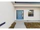 Bright blue front door, sidelights and adjacent window, concrete walkway, and textured stucco exterior wall at 17031 Sw 20Th Court Rd, Ocala, FL 34473