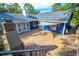 Outdoor brick patio area with a fireplace and a well maintained blue home with a grey roof at 1720 Overlook Rd, Longwood, FL 32750