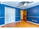 A well-lit bedroom featuring hardwood floors, a ceiling fan, and spacious closet at 1720 Overlook Rd, Longwood, FL 32750