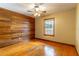 Cozy bedroom with wood-paneled accent wall and hardwood floors at 1720 Overlook Rd, Longwood, FL 32750