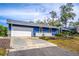 Blue home with white garage door and nicely landscaped yard at 1720 Overlook Rd, Longwood, FL 32750