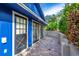 Exterior side view of a blue building with black framed glass doors and red brick pavers at 1720 Overlook Rd, Longwood, FL 32750