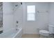 Clean bathroom with tub, shower, and window at 1726 Tree Shade Dr, Davenport, FL 33837