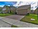 Two-story house with beige exterior, brick accents, and a two-car garage at 1726 Tree Shade Dr, Davenport, FL 33837