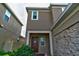 Front entrance with a brown door and stone accents at 1726 Tree Shade Dr, Davenport, FL 33837