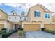 Two-story townhome with a two-car garage and landscaped walkway at 17454 Chateau Pine Way, Clermont, FL 34711