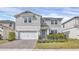 Two-story house with gray siding, a two-car garage, and a landscaped front yard at 17584 Saw Palmetto Ave, Clermont, FL 34714