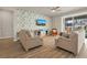 Living room with wood-look flooring, neutral-toned furniture, and a feature wall at 17584 Saw Palmetto Ave, Clermont, FL 34714