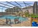 Screened pool with waterfall feature, spa, and comfortable seating at 17584 Saw Palmetto Ave, Clermont, FL 34714