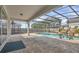 Enclosed pool and patio area, surrounded by screen, with a tranquil waterfall feature at 17584 Saw Palmetto Ave, Clermont, FL 34714