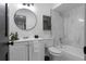 Clean bathroom with white vanity, marble shower, and round mirror at 2540 Albany Dr, Kissimmee, FL 34758