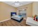 Cozy bedroom with a blue upholstered bed and wood floors at 2556 Antlia Dr, Orlando, FL 32828