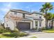 Two-story house with gray accents, a two-car garage, and palm trees at 2639 Calistoga Ave, Kissimmee, FL 34741