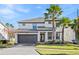 Two-story house with gray accents, a two-car garage, and palm trees at 2639 Calistoga Ave, Kissimmee, FL 34741