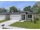 New construction home with a modern design, two-car garage, and landscaped lawn at 2920 Lingo Ln, Orlando, FL 32822