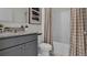 Bathroom with granite vanity, tiled shower, and checkered curtains at 2932 Moulin Rd, Davenport, FL 33837