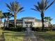 The community clubhouse, framed by palm trees and lush landscaping, creating a welcoming entrance at 2950 Timber Hawk Cir, Ocoee, FL 34761