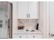 Kitchen detail showcases clean white cabinets, elegant countertops, and stylish accents near stainless steel appliances at 2950 Timber Hawk Cir, Ocoee, FL 34761