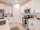 Bright kitchen featuring white cabinetry, stainless steel appliances, and tiled backsplash with modern finishes at 2950 Timber Hawk Cir, Ocoee, FL 34761