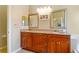 Double vanity bathroom with granite countertops and large mirrors at 2984 Cedar Glen Pl, Oviedo, FL 32765