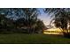 Serene lakeside yard with lush landscaping and sunset view at 4108 Downeast Ln, Windermere, FL 34786