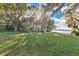 Expansive lawn area with mature trees and tranquil waterfront view at 4108 Downeast Ln, Windermere, FL 34786