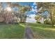 Brick pathway meanders through lush green lawn towards scenic waterfront at 4108 Downeast Ln, Windermere, FL 34786