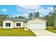 New construction home with a white garage door and landscaping at 431 Rainbow Ct, Kissimmee, FL 34759