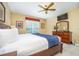 Comfortable bedroom featuring a ceiling fan, TV, and dresser with decorative mirror at 5012 Shoreway Loop # 10207, Orlando, FL 32819