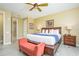 Bedroom featuring a king bed, ceiling fan, and accent bench at 5012 Shoreway Loop # 10207, Orlando, FL 32819