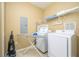 Laundry room with washer, dryer, ironing board, and shelving at 5012 Shoreway Loop # 10207, Orlando, FL 32819