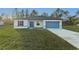 Beautiful single-story home with a blue garage door and well-kept lawn under a clear sky at 579 Marion Oaks Ln, Ocala, FL 34473