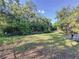 Large backyard with grassy area and mature trees at 7211 Pinion Dr, Orlando, FL 32818