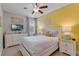 Bedroom with yellow accent wall, TV and ceiling fan at 7723 Graben St, Kissimmee, FL 34747