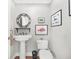 Elegant powder room with pedestal sink, decorative mirror, and framed art at 833 Ellwood Ave, Orlando, FL 32804