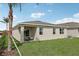 Home's exterior showcasing a covered patio and grassy backyard at 879 Pebble Crest Ln, Eagle Lake, FL 33839