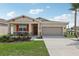 Charming one-story house with red accents, stone facade, and a two-car garage at 879 Pebble Crest Ln, Eagle Lake, FL 33839