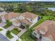 Aerial view of a home showcasing its well-manicured lawn, landscaping, and lake view at 8886 Fallen Oak Dr, Davenport, FL 33896