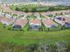 Community aerial view with well-maintained lawns, screened pools, and lush greenery at 8886 Fallen Oak Dr, Davenport, FL 33896
