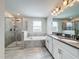 Beautiful bathroom featuring double sinks, shower, soaking tub, and neutral tile at 8886 Fallen Oak Dr, Davenport, FL 33896