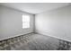 Neutral bedroom with gray carpet and natural light streaming through the window at 8886 Fallen Oak Dr, Davenport, FL 33896
