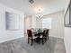 Well-lit dining room featuring a modern chandelier, a dining table set for six, and stylish wood-look tile flooring at 8886 Fallen Oak Dr, Davenport, FL 33896